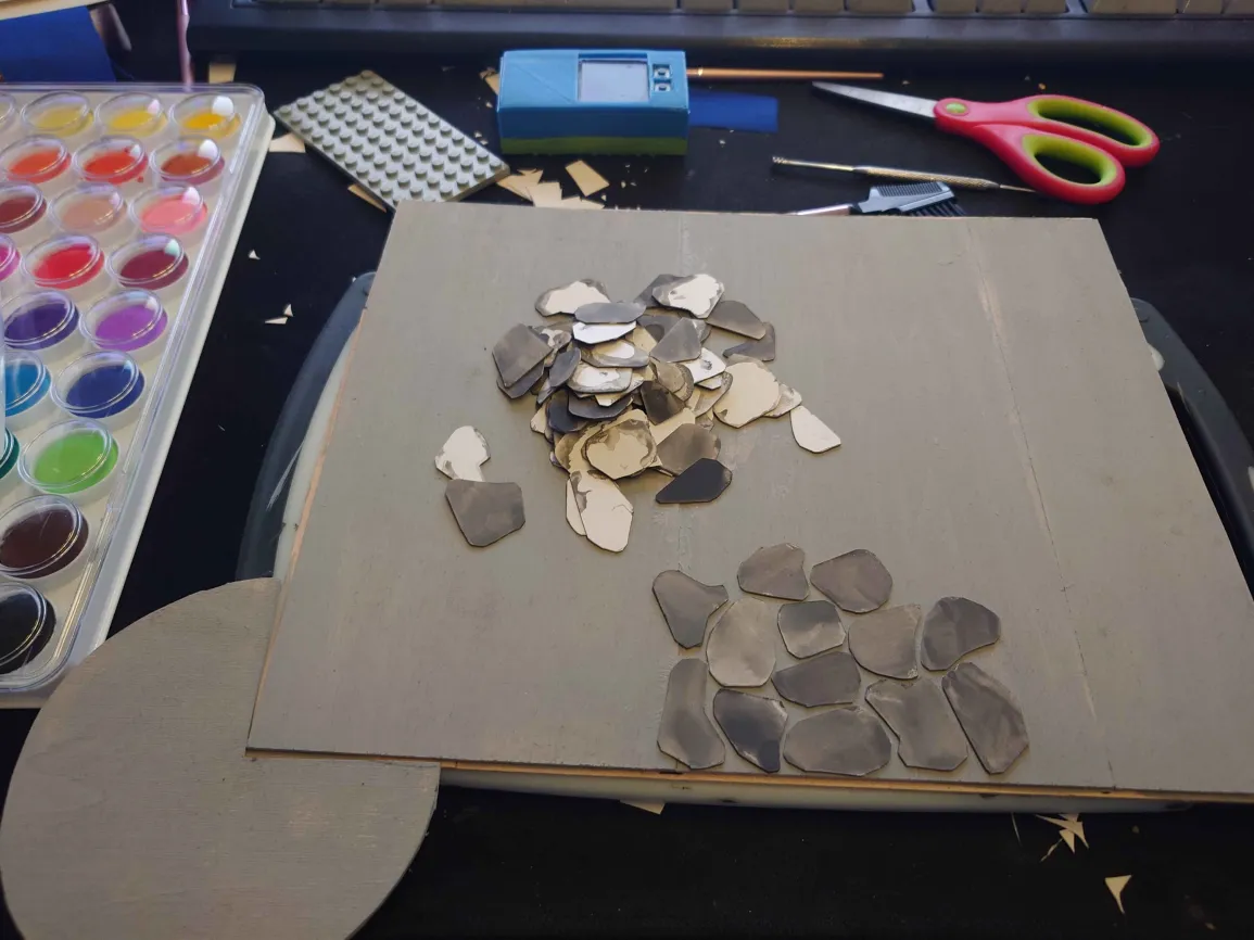 the floor, with a pile of paper stones