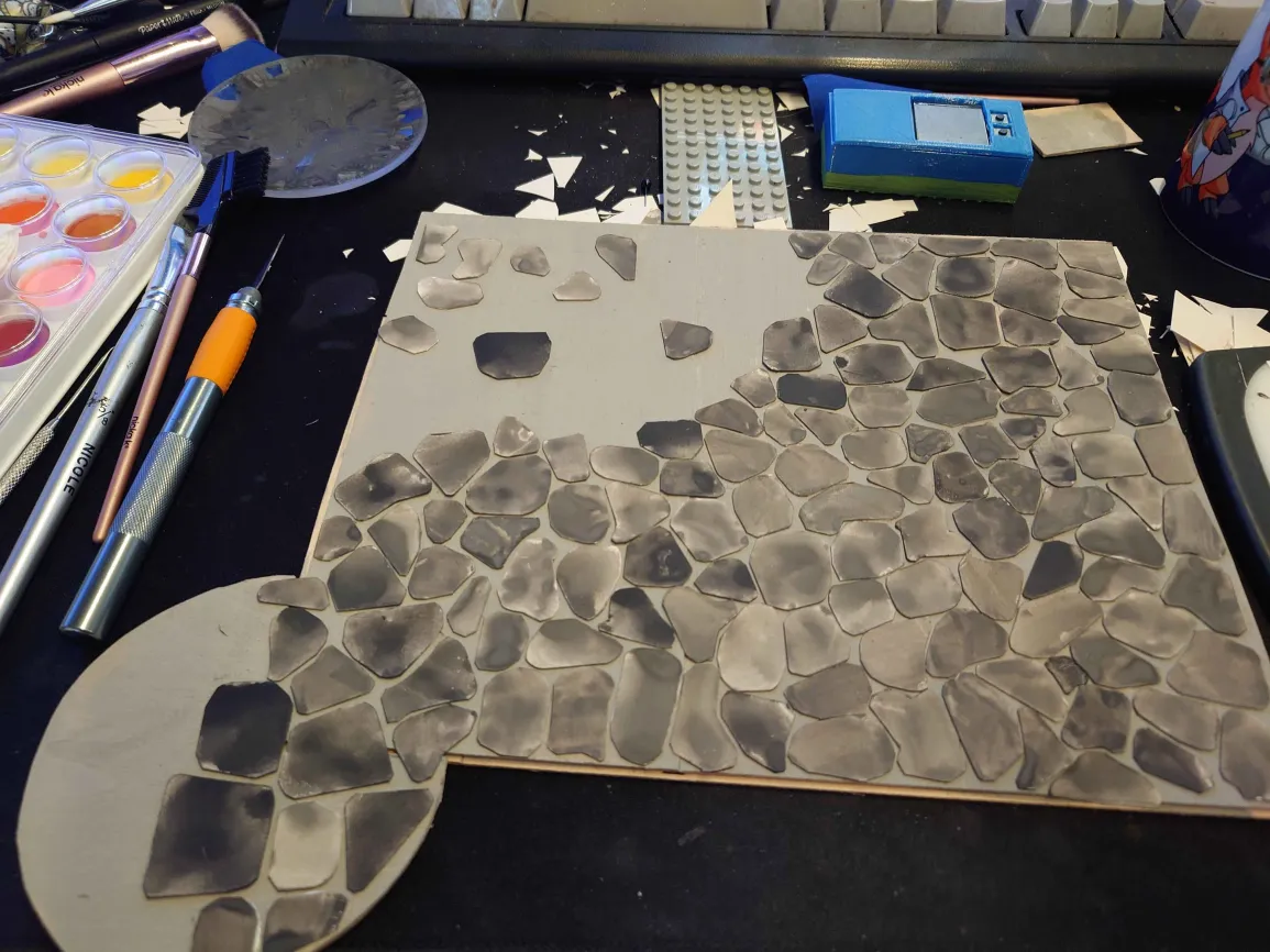 the floor, half covered in glued down paper stones.